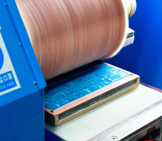 Surface finishing roller above a tray of blue Mahjong tiles