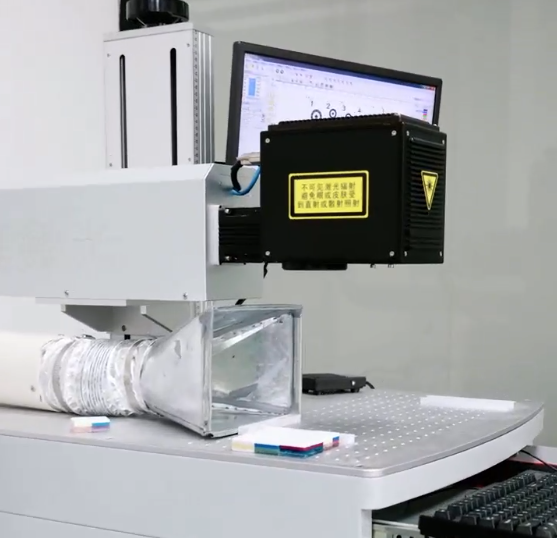 Laser marking workstation with layered Mahjong tiles on the work surface